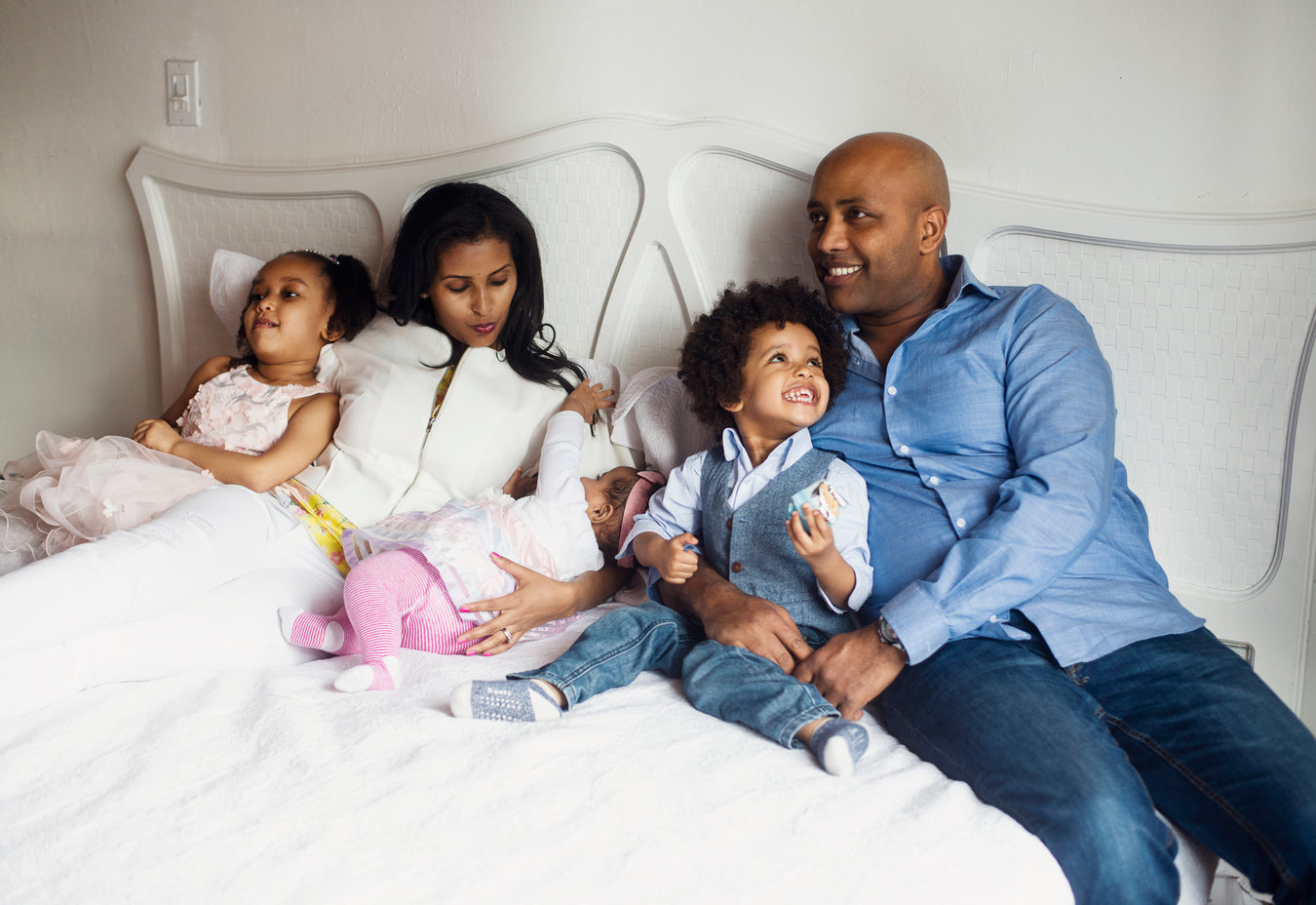 family sitting on a bed